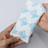 Desiccant silica on the pack. Closeup view. packet of silica gel buried in silica crystals, write in front that Do not eat in Chinese, Japanese and English.